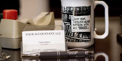 Your Accoutant LLC-branded business cards and pen in the Lakewood office