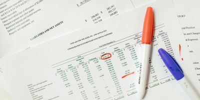 Printed documents with financial reports showing financial expenses via balance sheets
