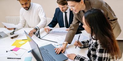 Four professionals in a business meeting reviewing tax plan