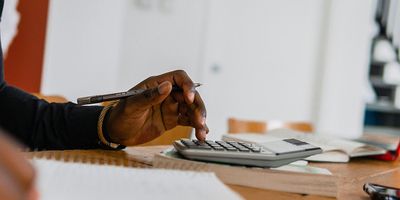 Female property investor inputting tax calculations into a calculator