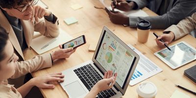 Property owner and accountants sitting around table with data sheets of expenses