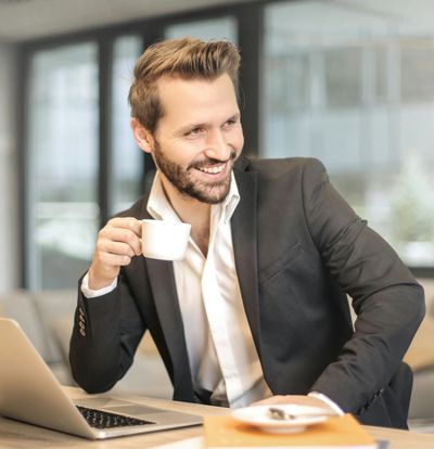 Business man sitting at desk with coffee, CO
