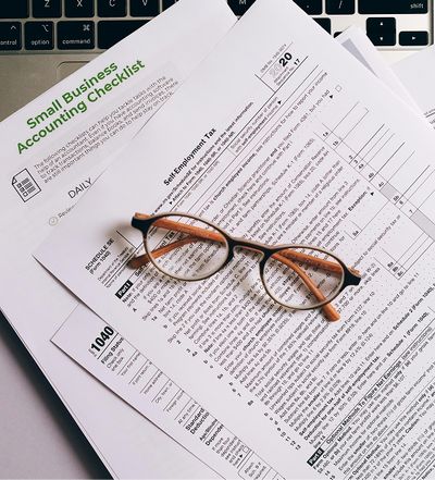 Business tax documents with a pair of glasses resting on them, CO